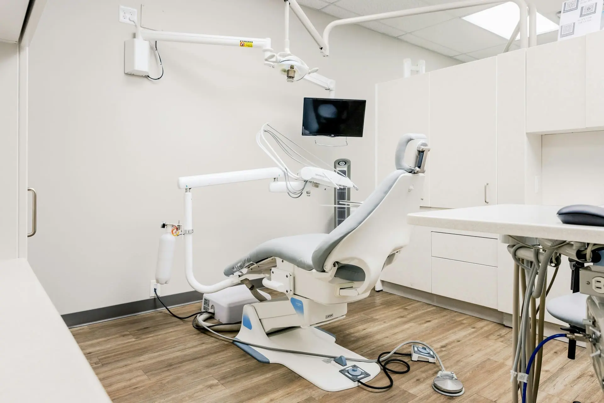 UBCS | Dental construction serivces HVAC the image showcase  A modern dental room featuring a chair and desk, designed for optimal patient care and equipped with an HVAC system.